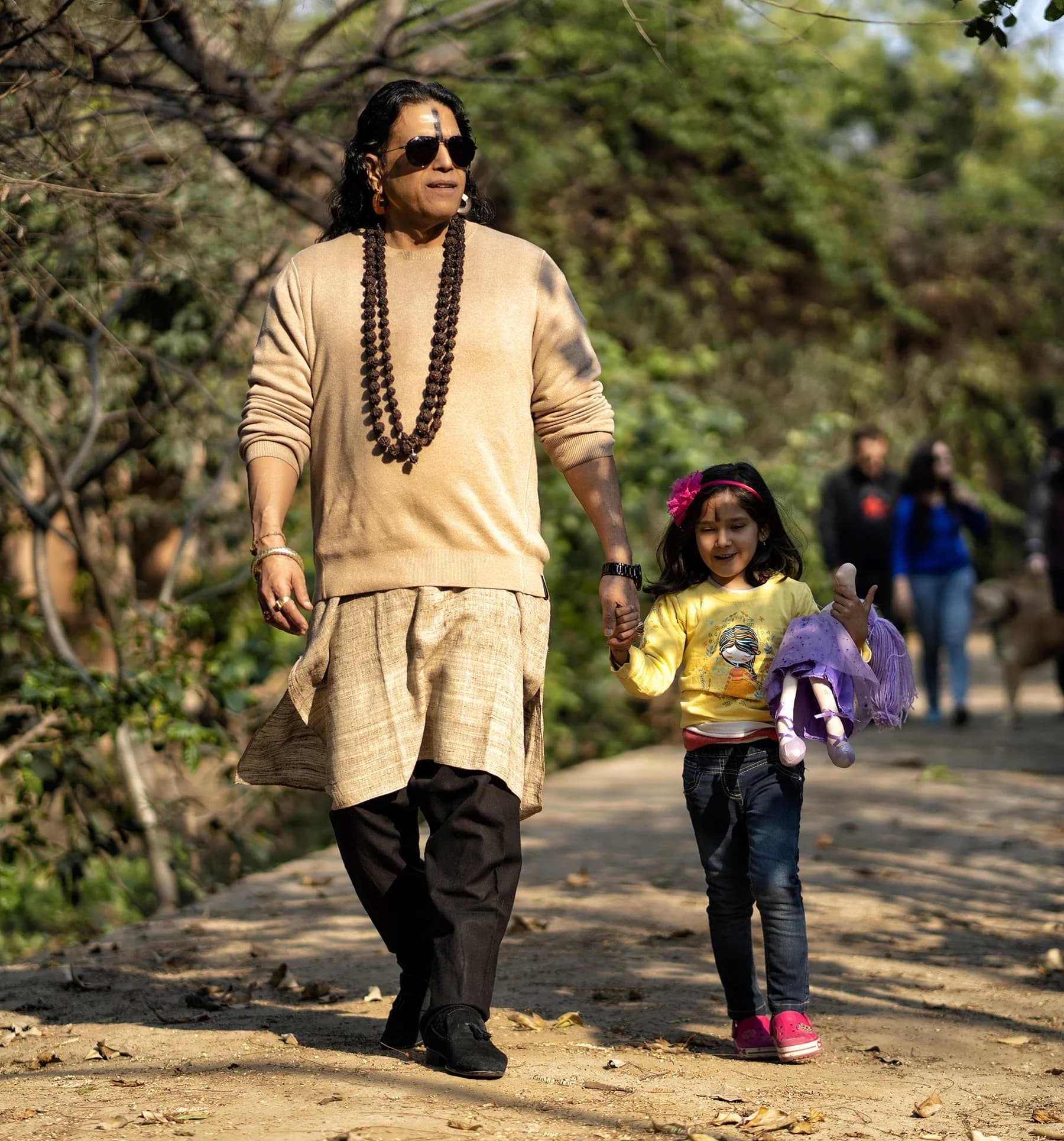 Guruji Sri Shailendra Sharma walking outdoors with a child